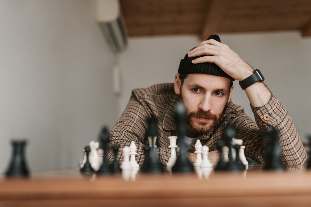 a man is playing chess and trying to find out the plan